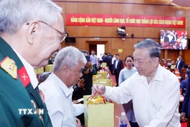 Tổng Bí thư Tô Lâm tặng quà cho đại diện gia đình chính sách, người có công. (Ảnh: Thống Nhất/TTXVN)