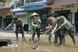 Hàng trăm cán bộ, chiến sỹ Công an tỉnh Lào Cai giúp đỡ nhân dân khắc phục hậu quả mưa lũ. (Ảnh: Đinh Thùy/TTXVN)