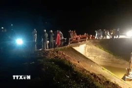 Hàng trăm người và phương tiện đang triển khai các biện pháp phòng chống vỡ đập tại hồ thủy lợi Cay An. (Ảnh: TTXVN phát)