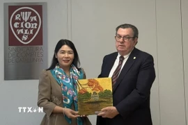 Phó Tổng KTNN Hà Thị Mỹ Dung tặng quà lưu niệm cho ông Miquel Salazar Canalda, Chủ tịch Cơ quan Kiểm toán vùng Catalonia. (Ảnh: TTXVN phát)