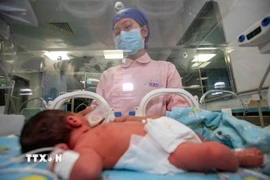 Chăm sóc trẻ sơ sinh tại bệnh viện ở tỉnh Chiết Giang, Trung Quốc. (Ảnh: AFP/TTXVN)