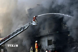 Lính cứu hỏa nỗ lực dập lửa vụ cháy tòa nhà Trung tâm thương mại ở Karachi, Pakistan ngày 18/1/2026. (Ảnh: THX/TTXVN)