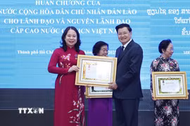 Tổng Bí thư, Chủ tịch nước Lào Thongloun Sisoulith trao Huân chương Tự do hạng Nhất của Nhà nước Lào tặng Phó Chủ tịch nước Võ Thị Ánh Xuân. (Ảnh: Lâm Khánh/TTXVN)