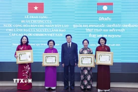 Tổng Bí thư, Chủ tịch nước Lào Thongloun Sisoulith trao Huân chương Tự do hạng Nhất của Nhà nước Lào tặng Phó Chủ tịch nước Võ Thị Ánh Xuân và các nguyên Phó Chủ tịch nước Trương Mỹ Hoa, Nguyễn Thị Doan và Đặng Thị Ngọc Thịnh. (Ảnh: Lâm Khánh/TTXVN)