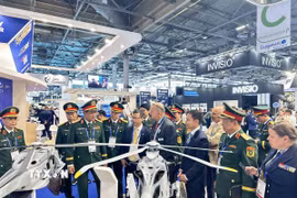 Thượng tướng Nguyễn Trường Thắng cùng đoàn công tác nghe đối tác Pháp giới thiệu về mô hình máy bay trực thăng chiến đấu. (Ảnh: Ngọc Hiệp/TTXVN)