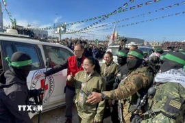 Các thành viên Lữ đoàn Al-Qassam và Al-Quds tiến hành lễ trao trả 4 nữ binh sĩ Israel cho Ủy ban Chữ thập đỏ quốc tế (ICRC) tại thành phố Gaza, ngày 25/1/2025. (Ảnh: AA/TTXVN)