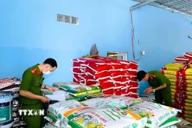 Cán bộ Phòng Cảnh sát kinh tế kiểm tra, phát hiện các sản phẩm không rõ nguồn gốc, xuất xứ. (Ảnh: Hữu Đệ/TTXVN phát)