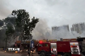 Khoảng 10 xe chuyên dụng cùng hàng chục cảnh sát huy động tới hiện trường để dập lửa và cứu nạn cứu hộ. (Ảnh: TTXVN phát)