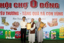 Đại diện Ủy ban Mặt trận Tổ quốc Việt Nam phường Hàm Thắng trao thư cảm ơn cho Ban từ thiện xã hội Giáo hội Phật giáo Việt Nam tỉnh Lâm Đồng. (Ảnh: Hồng Hiếu/TTXVN)