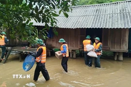 Đồn Biên phòng Làng Ho (Bộ đội Biên phòng Quảng Bình) hỗ trợ, giúp đỡ di dời 10 hộ, 52 người dân bản Mít Cát, xã Kim Thủy, huyện Lệ Thủy đến vị trí an toàn. (Ảnh: TTXVN phát)