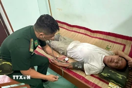 Lực lượng chăm sóc sức khỏe cho ngư dân trên tàu gặp nạn. (Ảnh: TTXVN)
