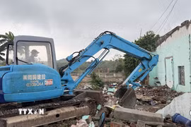 Máy móc được huy động hỗ trợ người dân xã Tuy An Đông bàn giao mặt bằng. (Ảnh: Tường Quân/TTXVN)