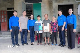 Đoàn công tác Trung ương Đoàn thăm tặng quà gia đình anh Võ Quốc Tâm ở xã Đồng Tiến, Hà Tĩnh có hoàn cảnh đơn thân nuôi 3 con nhỏ, gia đình bị thiệt hại bởi bão số 10. (Ảnh: TTXVN phát)