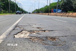 Đường ĐT.741 xuất hiện nhiều "ổ voi, ổ gà" gây nguy hiểm cho người đi đường. (Ảnh: Đậu Tất Thành/TTXVN)