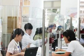 Cán bộ, công chức tại Trung tâm Hành chính công phường Sài Gòn mới đang khẩn trương xử lý hồ sơ. (Ảnh: Hữu Duyên/TTXVN)