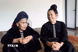 Nữ dân quân Yên Châu Quàng Thị Lói (trái) và Quàng Thị Hổn cùng ôn lại chiến công bắn rơi máy bay Mỹ năm xưa. (Ảnh: Quang Quyết/TTXVN)