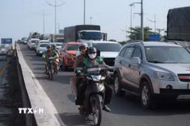 Các phương tiện lưu thông đông đúc trên Quốc lộ 1 (đoạn qua xã Tân Nhựt) hướng về các tỉnh, thành miền Tây. (Ảnh: Hồng Đạt/TTXVN)