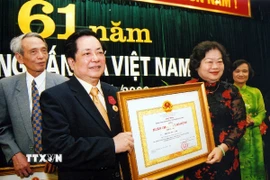 Phó Chủ tịch nước Trương Mỹ Hoa trao Huân chương Lao động hạng Nhì tặng Phó Tổng Giám đốc Thông tấn xã Việt Nam Trương Đức Anh nhân dịp kỷ niệm 61 năm Ngày truyền thống Thông tấn xã Việt Nam, tháng 9/2006.