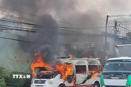 Chiếc xe cấp cứu bốc cháy dữ dội trên Quốc lộ 13 đoạn qua thành phố Thuận An, tỉnh Bình Dương. (Ảnh: TTXVN phát)