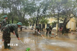 Các chiến sỹ Trung đoàn 6, Bộ Chỉ huy Quân sự thành phố Huế hỗ trợ nhân dân dọn dẹp vệ sinh sau mưa lũ. (Ảnh: Mai Trang/TTXVN)