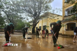 Các chiến sỹ Trung đoàn 6, Bộ Chỉ huy Quân sự thành phố Huế hỗ trợ nhân dân dọn dẹp vệ sinh sau mưa lũ. (Ảnh: Mai Trang/TTXVN)