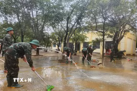 Các chiến sỹ Trung đoàn 6, Bộ Chỉ huy Quân sự thành phố Huế hỗ trợ nhân dân dọn dẹp vệ sinh sau mưa lũ. (Ảnh: Mai Trang/TTXVN)