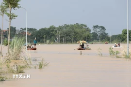 Do tuyến đường bị ngập sâu trong nước nhiều người dân xã Sơn Đông đã phải dùng thuyền để di chuyển, gây khó khăn trong việc đi lại của người dân. (Ảnh: Tạ Toàn/TTXVN)