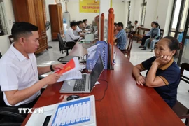 Người dân xã Phong Nha, một trong những xã lớn sau sáp nhập của tỉnh Quảng Trị, thực hiện giải quyết thủ tục hành chính tại Trung tâm phục vụ hành chính công xã Phong Nha. (Ảnh: Kha Phạm/TTXVN)