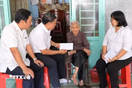 Lãnh đạo Đảng ủy, HĐND, UBND, Ủy ban MTTQ Việt Nam phường Phú Lợi trao quà tặng của Đảng, Nhà nước nhân dịp chào mừng Đại hội đại biểu toàn quốc lần thứ XIV của Đảng và Tết Nguyên đán Bính Ngọ năm 2026, cho người được thụ hưởng tại nhà. (Ảnh: Huyền Trang/TTXVN)