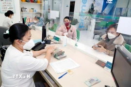 Khách hàng giao dịch tại một ngân hàng. (Ảnh: Trần Việt/TTXVN)