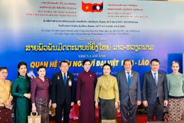 Hai phu nhân chụp ảnh cùng các đại biểu tại Lễ Khai mạc Tuần phim Việt Nam tại Lào và Triển lãm ảnh quan hệ Việt Nam-Lào. (Nguồn: Báo Thể thao và Văn hóa)