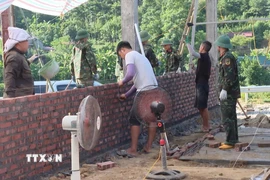 Lực lượng thuộc Bộ Chỉ huy quân sự tỉnh Phú Thọ chung sức giúp đồng bào xoá nhà tạm, nhà dột nát tại xã Xuân Đài. (Ảnh: Đào An/TTXVN)