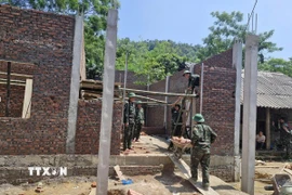 Lực lượng quân đội của Bộ Chỉ huy quân sự tỉnh Phú Thọ chung sức giúp đồng bào xóa nhà tạm, nhà dột nát tại xã Xuân Đài. (Ảnh: Đào An/TXVN)