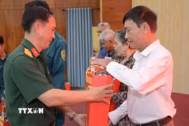 Thừa ủy quyền của Quân ủy Trung ương, Bộ Quốc phòng, Bộ Chỉ huy Quân sự tỉnh An Giang trao quà cho các gia đình chính sách, người có công với cách mạng Châu Thành. (Ảnh: Văn Sĩ/TTXVN)