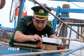 Cán bộ chiến sỹ Trạm Kiểm soát Biên phòng Pháo Đài thuộc Đồn Biên phòng cửa khẩu quốc tế Hà Tiên kiểm tra thiết bị giám sát hành trình tàu cá. (Ảnh: Lê Huy Hải/TTXVN)