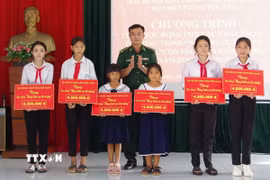 Thượng tá Nguyễn Quốc Việt, Chính ủy Bộ đội Biên phòng tỉnh Ninh Bình, tặng quà cho các gia đình gia đình có hoàn cảnh khó khăn và "Con nuôi Đồn Biên phòng". (Ảnh: Đức Phương/TTXVN)