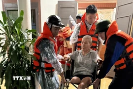 Sơ tán người dân ở vùng ngập lụt thị trấn Lao Bảo đến nơi an toàn. (Ảnh: TTXVN phát)