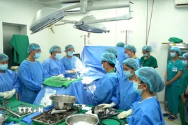 Các y bác sỹ mặc niệm tri ân người hiến tạng trước khi tiến hành lấy tạng. (Ảnh: TTXVN phát)