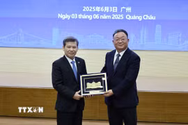 Ông Lê Minh Trí, Chánh án Tòa án Nhân dân Tối cao Việt Nam trao quà lưu niệm tặng Tòa án Nhân dân cấp cao tỉnh Quảng Đông, Trung Quốc. (Ảnh: Công Tuyên/TTXVN)