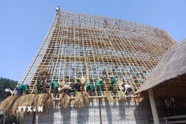 Người dân lợp lại mái nhà rông. (Ảnh: Hồng Điệp/TTXVN)