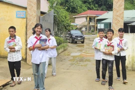 Học sinh Trường Phổ thông Dân tộc bán trú THCS Chiềng Sơ (xã Mường Luân) vui mừng khi được tặng sách giáo khoa mới. (Ảnh: TTXVN phát)