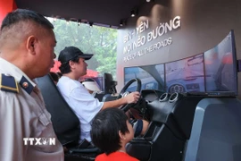 Người dân trải nghiệm xử lý tình huống lái xe ôtô thực tế ảo. (Ảnh: Hoàng Hiếu/TTXVN)