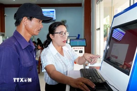 Hướng dẫn người dân tra cứu hồ sơ trực tuyến tại phường Nghĩa Lộ. (Ảnh: Lê Phước Ngọc/TTXVN)