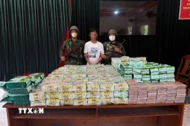 Đối tượng vận chuyển trái phép ma túy bị bắt giữ cùng tang vật hơn 295kg ma túy. (Ảnh: TTXVN phát)