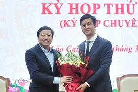 Đồng chí Dương Quốc Huy, Ủy viên Ban Chấp hành Trung ương Đảng, Bí thư Tỉnh ủy tặng hoa chúc mừng đồng chí Phan Trung Bá. (Ảnh: Tuấn Khôi/TTXVN)