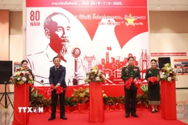 Đại sứ Việt Nam tại Lào Nguyễn Minh Tâm (bên trái) và Trung tướng Vongsone Inpanphim, Chủ nhiệm Tổng Cục Chính trị Quân đội, Thứ trưởng Bộ Quốc phòng Lào cắt băng khai mạc Triểm lãm ảnh chuyên đề Kỷ niệm Quốc khánh Việt Nam tròn 80 năm. (Ảnh: Xuân Tú/TTXVN)