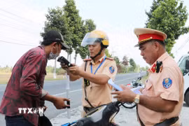 Cảnh sát giao thông Công an tỉnh An Giang kiểm tra nồng độ cồn. (Ảnh: Văn Sĩ/TTXVN)