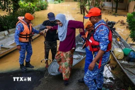 Lực lượng cứu hộ sơ tán người dân khỏi vùng ngập lụt tại Kelantan, Malaysia ngày 26/11/2025. (Ảnh: THX/TTXVN)