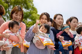 Các bậc phụ huynh bế con trước cuộc thi Nakisumo (hay còn gọi là cuộc thi Sumo dọa em bé khóc) tại chùa Sensoji ở Tokyo ngày 26/4/2025. (Ảnh: AFP/Getty Images)