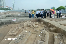 Các chuyên gia nghiên cứu và truyền thông tham quan các hố khai quật ở Vườn Chuối. (Ảnh: Phương Anh/Vietnam+)